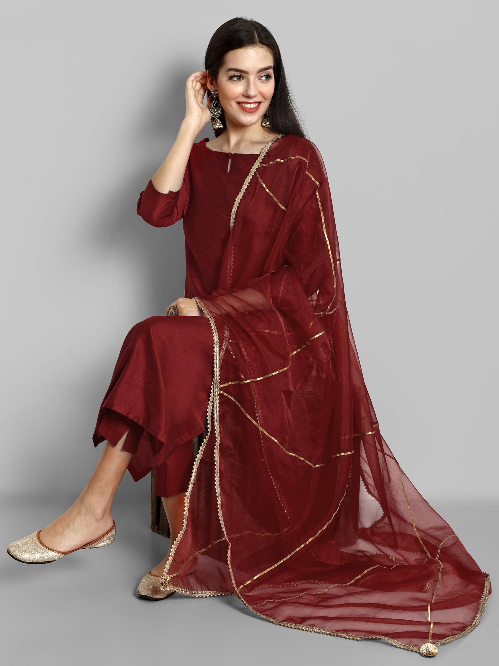 Maroon boat neck kurta paired with elasticated pants and an organza dupatta - a stylish set of three for a sophisticated and coordinated look